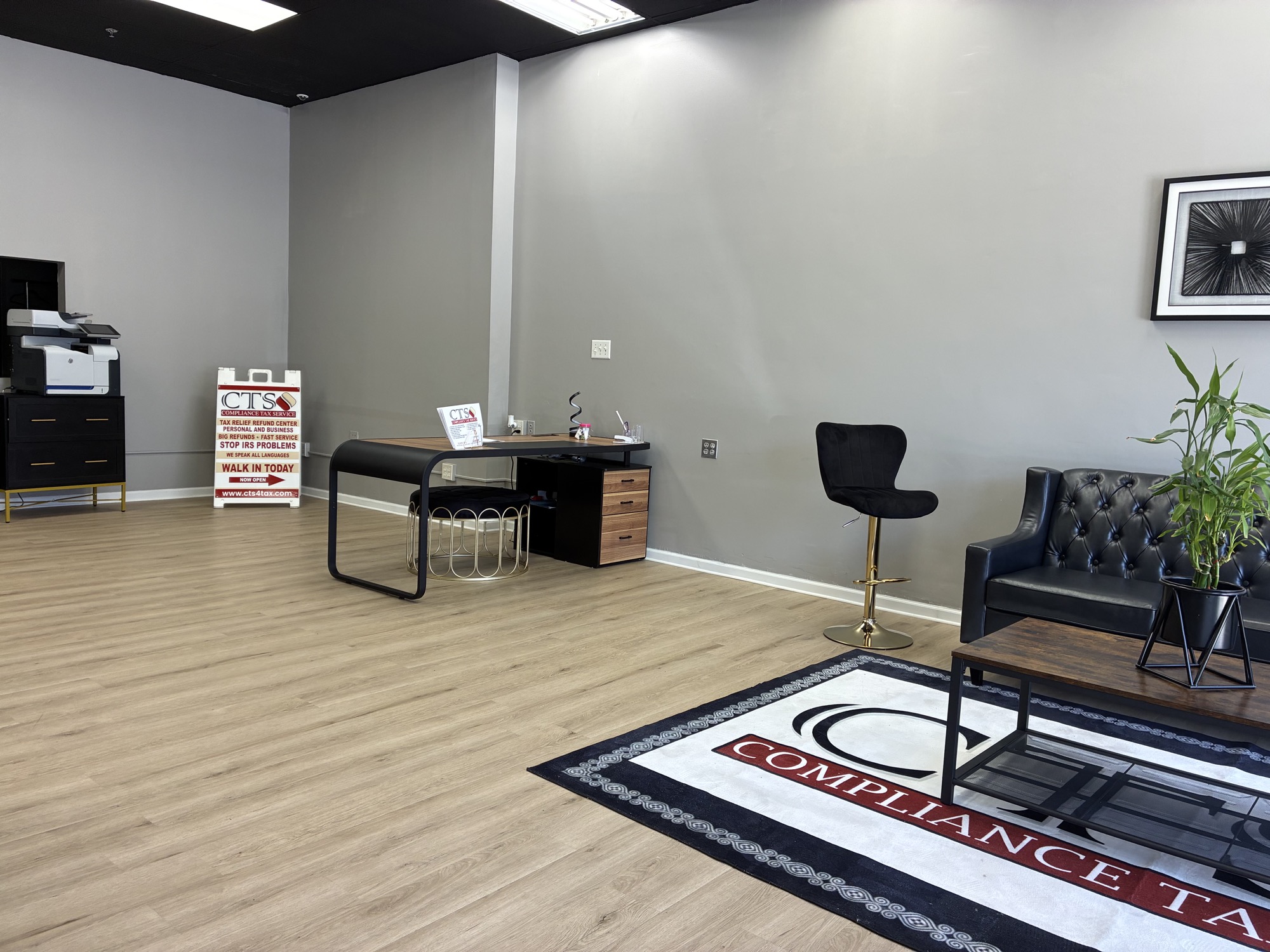 The Compliance Tax Service waiting lounge, with a CTS-branded rug and Chesterfield sofa.